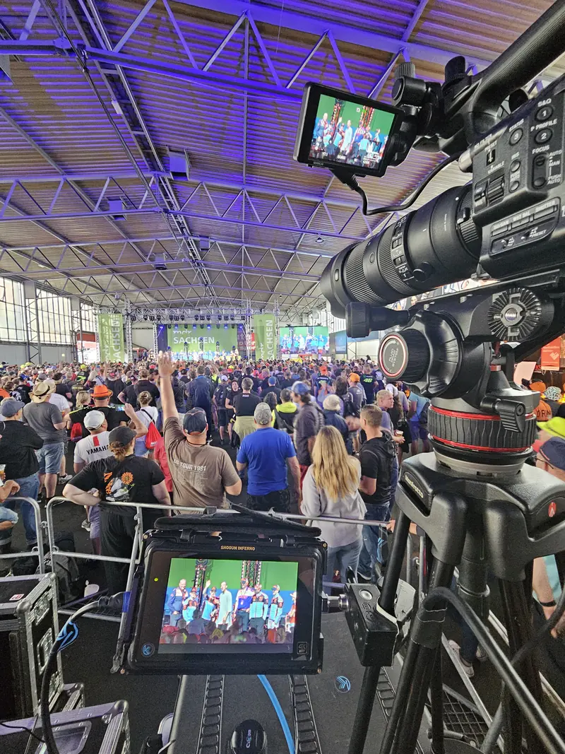 Kamera mit Monitor über dem Publikum in einer vollen Halle