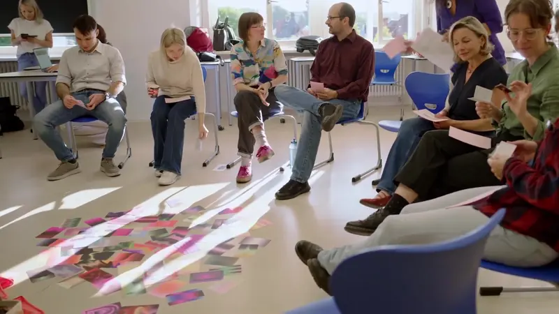 Seminarrunde im Stuhlkreis, Sonnenlicht fällt auf bunte Karten am Boden – Imagefilm NextGen der Hochschule Mittweida